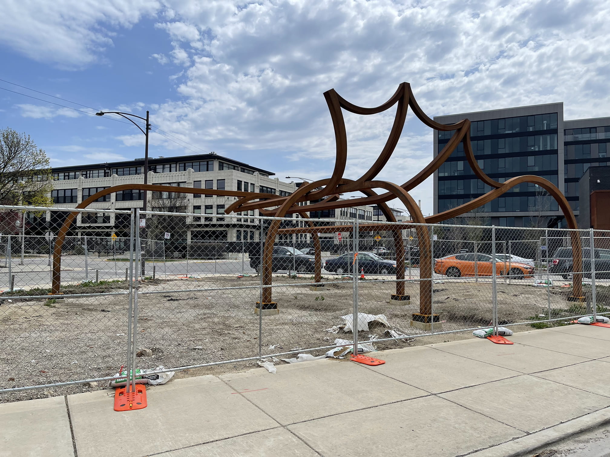 Big ass sculpture behind a fence across from a police station